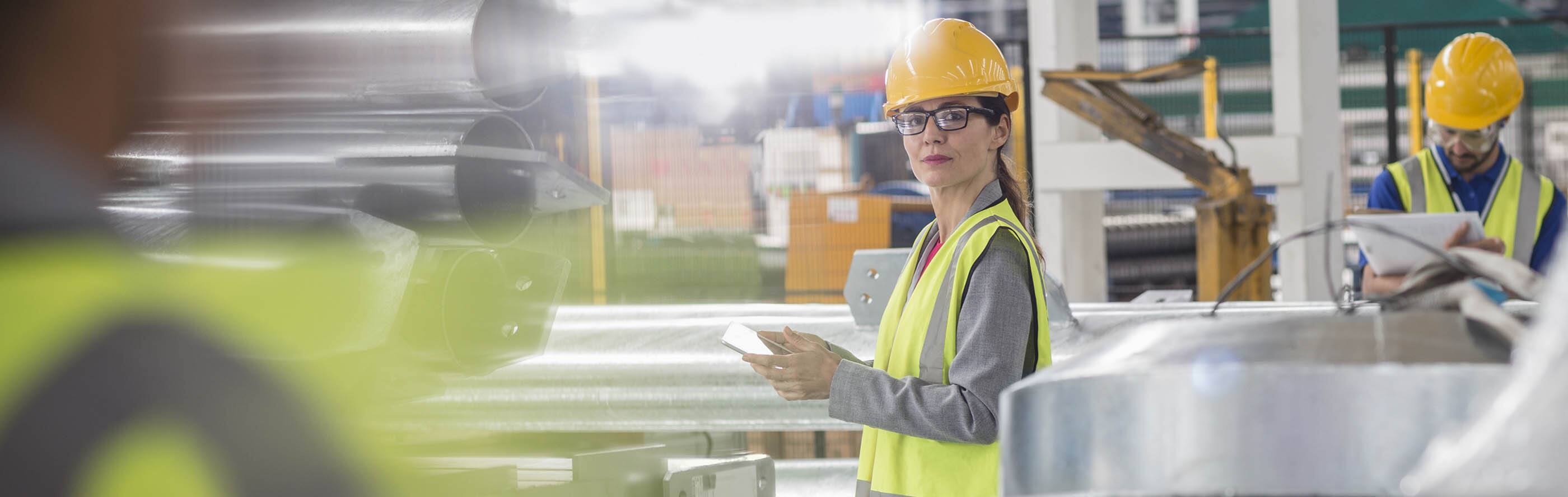 Lady checking phone in factory