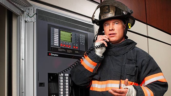 A fire control personnel talking over the fire alarm control panel