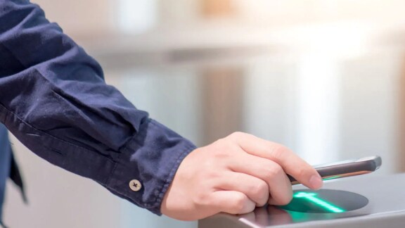 A man scanning his device in a security access device 