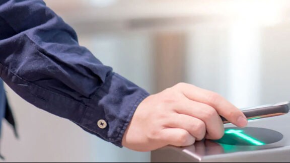 A man scanning his device in a security access device 