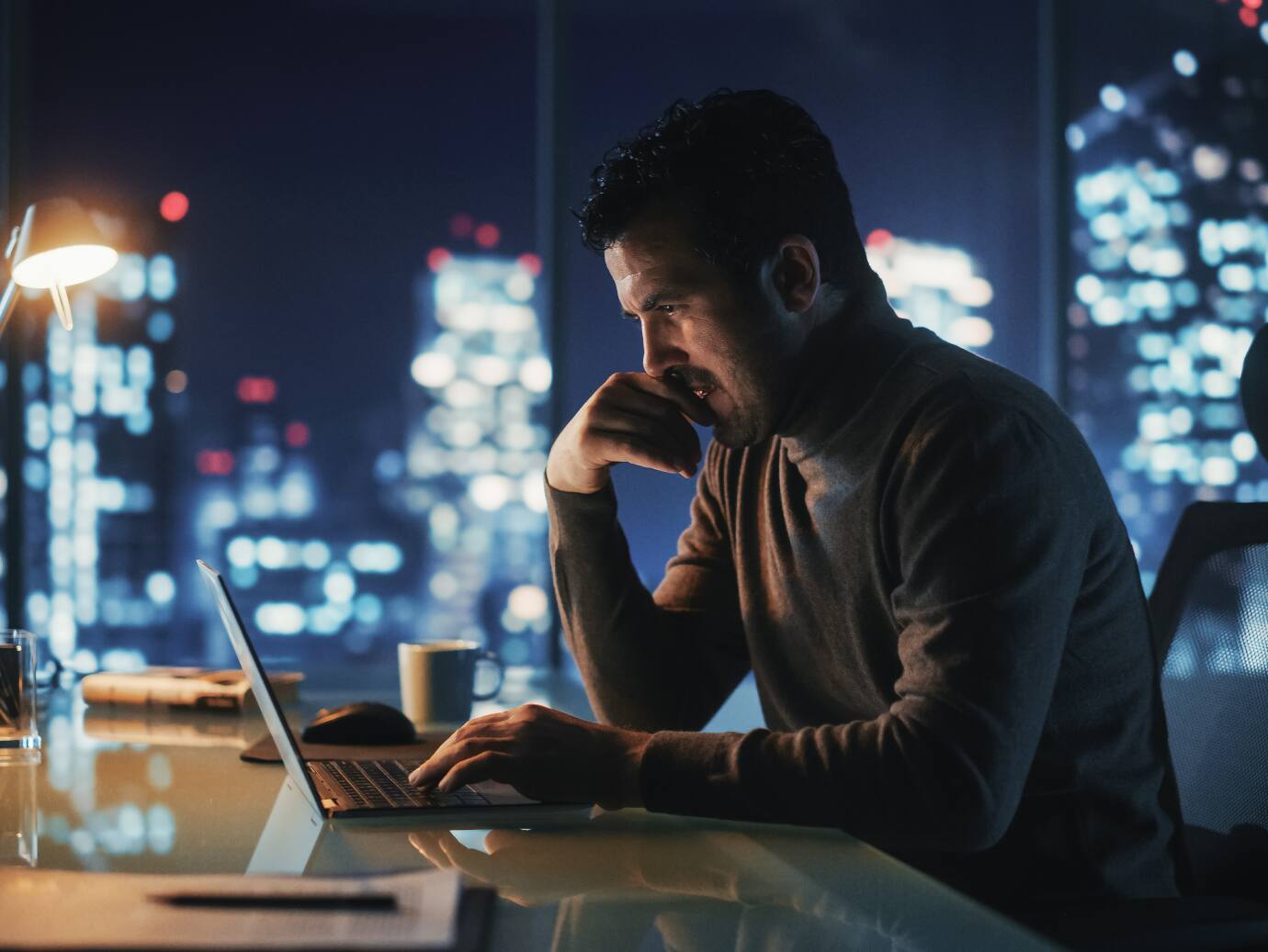 Man working on laptop on table with chair